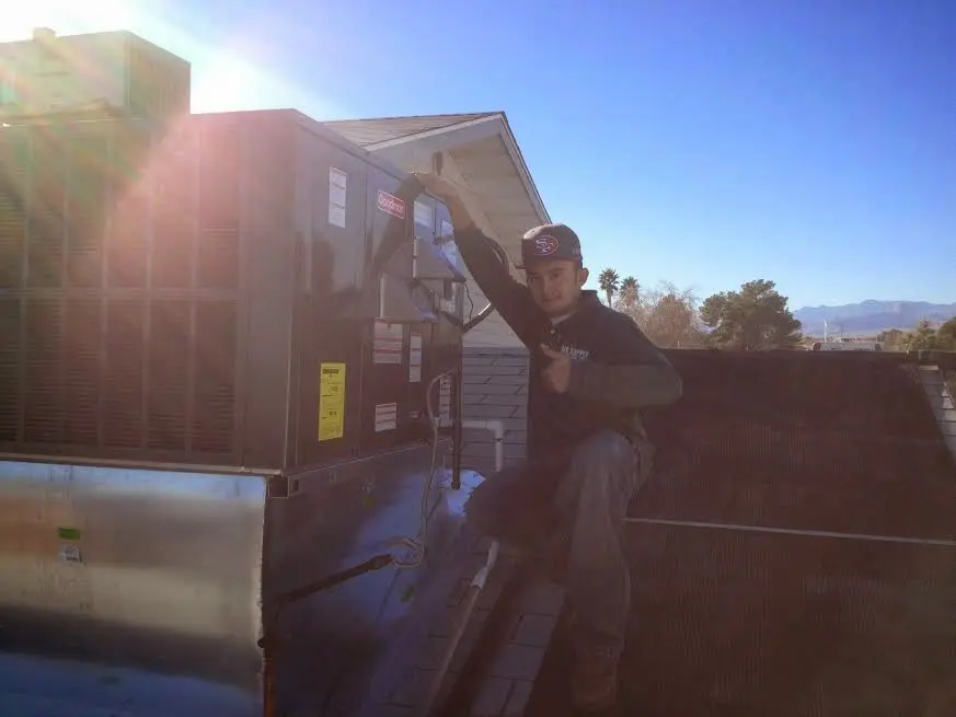HVAC technician performing HVAC Inspection on a rooftop unit in Pontotoc